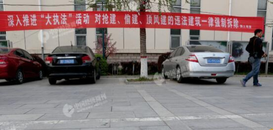 p29-2 雄县人民政府附近一栋建筑外悬挂的打击违建的宣传语。