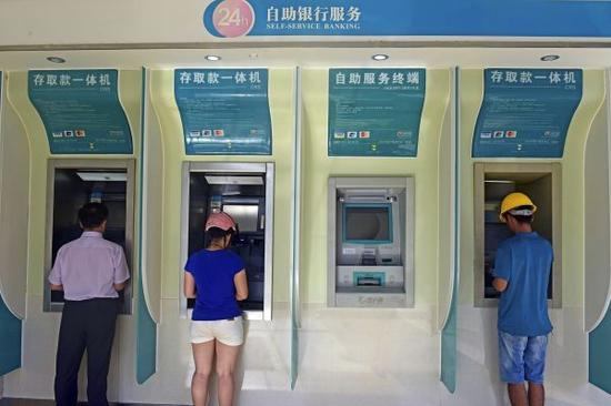 7月31日，储户在海南琼海的一处银行自动柜员机前办理业务。