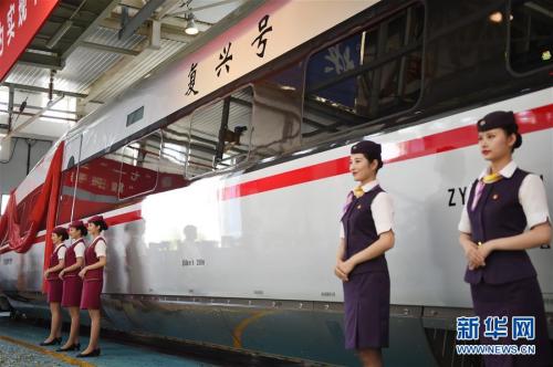 6月25日，乘务人员站在“复兴号”中国标准动车组CR400AF型列车旁。新华社记者 鞠焕宗 摄 图片来源：新华网